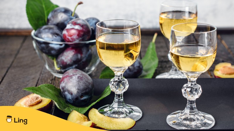 Schuessel mit Pflaumen, daneben 3 Glaeser mit Pflaumen-Raki