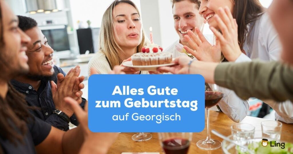 Blonde Frau bläst Kerzen auf Geburtstagstorte während ihre Freunde Alles Gute zum Geburtstag auf Georgisch wünschen