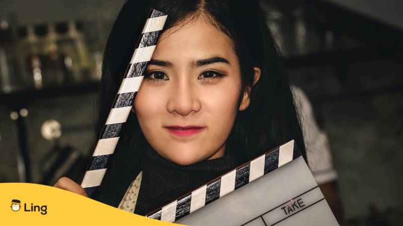 Andere junge Filipino Schauspielerin ist glücklich in einer Gastrolle mit Filmklappe am Set