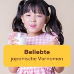 Ein japanisches Mädchen trinkt ein Glas Milch und zeigt den Daumen hoch, im Vordergrund der Titel des Blogposts: beliebte japanische Vornamen