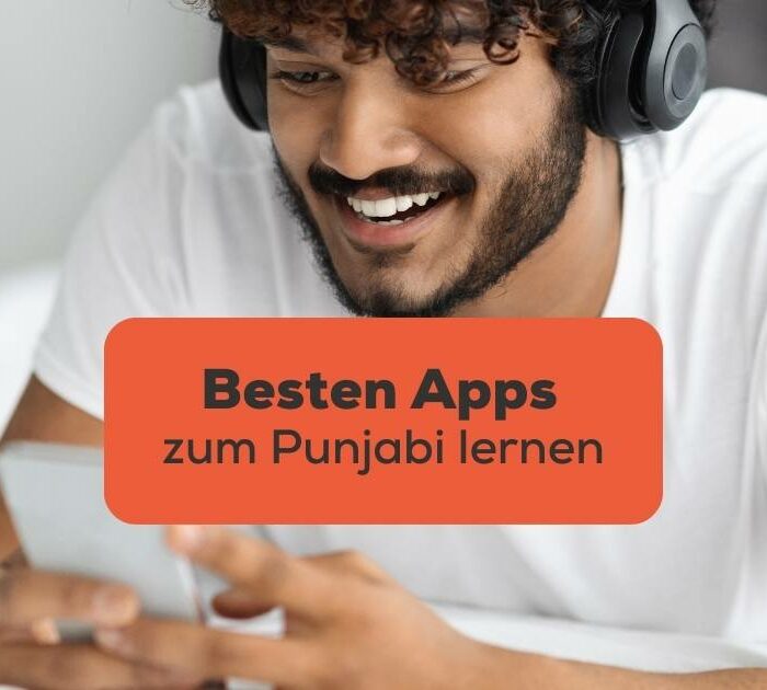 Dunkelhaariger Mann hat schwarze Kopfhörer an und Handy in der Hand und sucht nach den Besten Apps zum Punjabi lernen mit der Ling-App