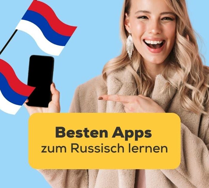 Blonde Frau zeigt begeistert auf ihr Handy nach dem sie nach den besten Apps zum Russisch lernen gesucht hat und die Ling-App gefunden hat