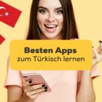 Dunkelhaarige Frau hält Handy in der Hand und recherchiert nach den besten Apps zum Türkisch lernen und hat die Ling-App gefunden