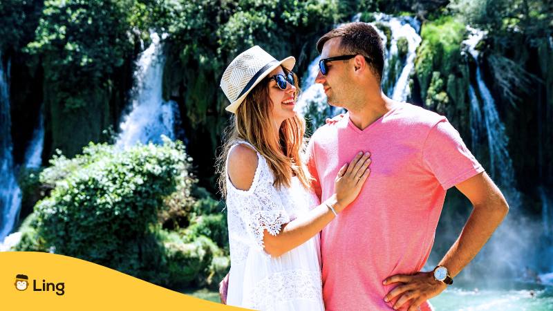 Paar steht vor dem Kravice Wasserfall in Bosnien