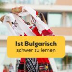 Frauen tanzen in traditioneller buglarischer Tracht und können die Frage beantworten Ist Bulgarisch schwer zu lernen?
