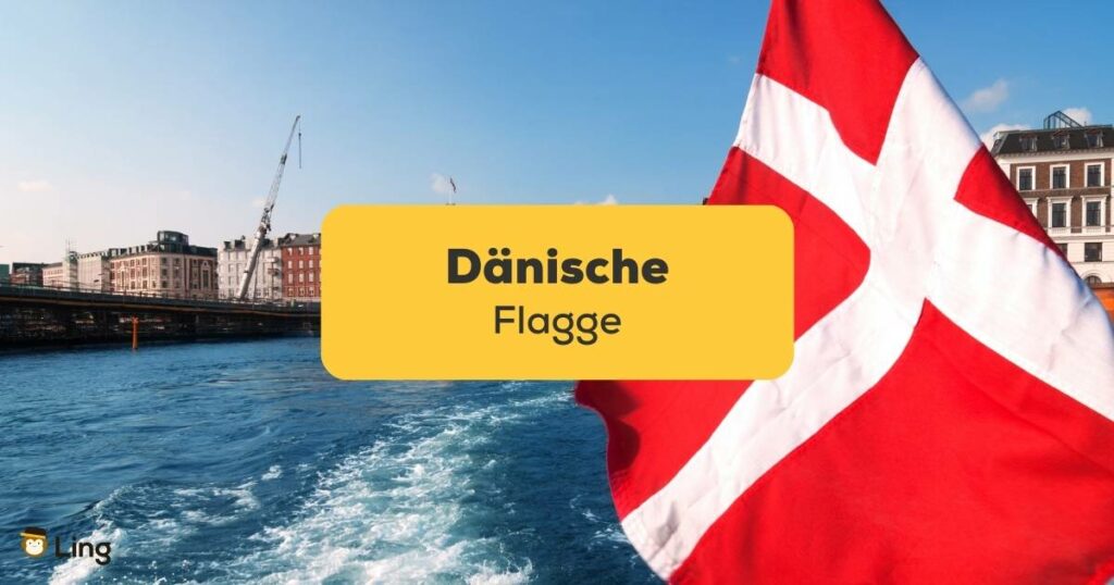 Dänische Flagge wird gehiesst an einem Boot, das durch einen dänischen Hafen fährt