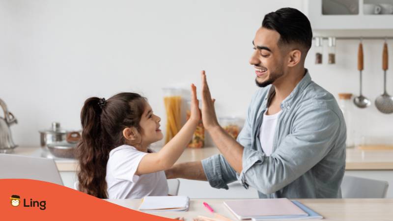 Vater lernt mit seiner Tochter und macht mit ihr High Five, sie hat einen georgischen Mädchennamen
