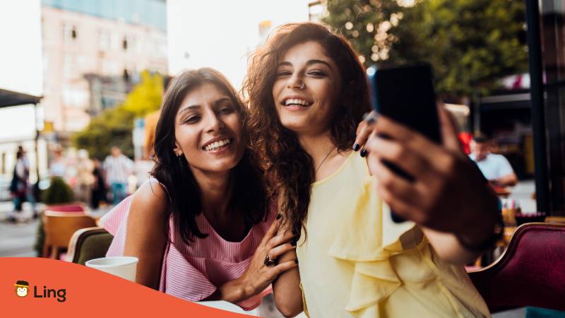 Zwei Freundinnen treffen sich und machen zusammen ein Selfie, beide haben georgische Namen