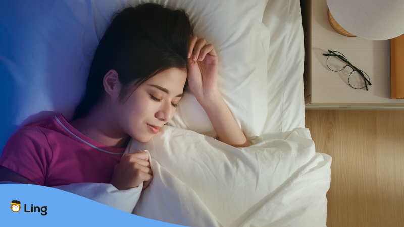Vietnamesische Frau liegt friedlich im Bett, nachdem sie Süße Nacht auf Vietnamesisch gewünscht hat
