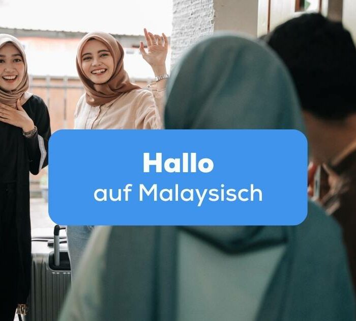 Zwei Frauen im Kopftuch stehen an der Türe und winken um Hallo auf Malaysisch zu sagen