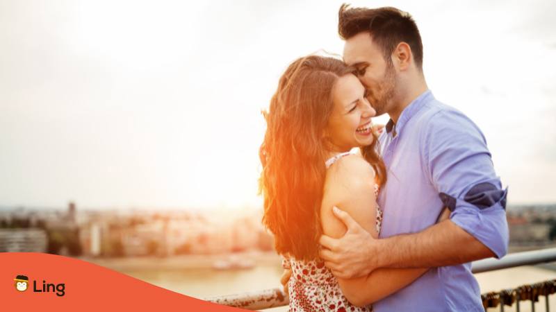 Mann küsst Frau auf die Wange und umarmt sie um ihr zu sagen Ich liebe dich auf Serbisch