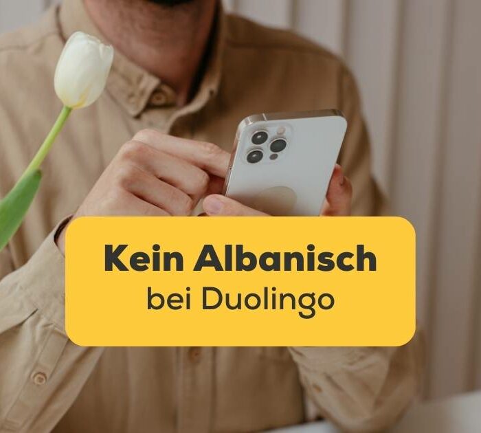 Mann hat Handy in der Hand und wundert sich warum es kein Albanisch bei Duolingo gibt, aber es gibt zwei wunderbare Alternativen