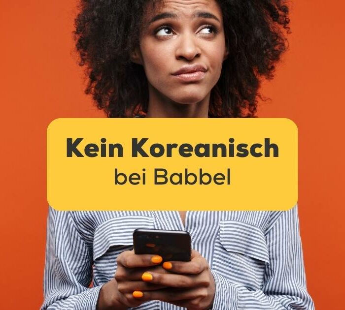 Frau schaut frustriert auf ihr Handy, weil sie kein Koreanisch auf Babbel finden kann, aber wir haben zwei wunderbare Alternativen gefunden