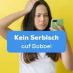 Frau hält Handy in der Hand und rauft sich die Haare weil es kein Serbisch auf Babbel gibt