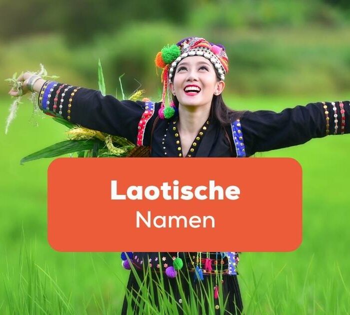 Laotische Frau in traditioneller Tracht streckt ihre Arme in die Luft und freut sich, dass sie beliebte laotische Namen kennt