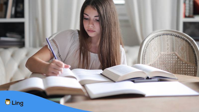 Mädchen sitzt am Schreibtisch mit vielen Büchern und fragt sich Ist Kroatisch schwer zu lernen