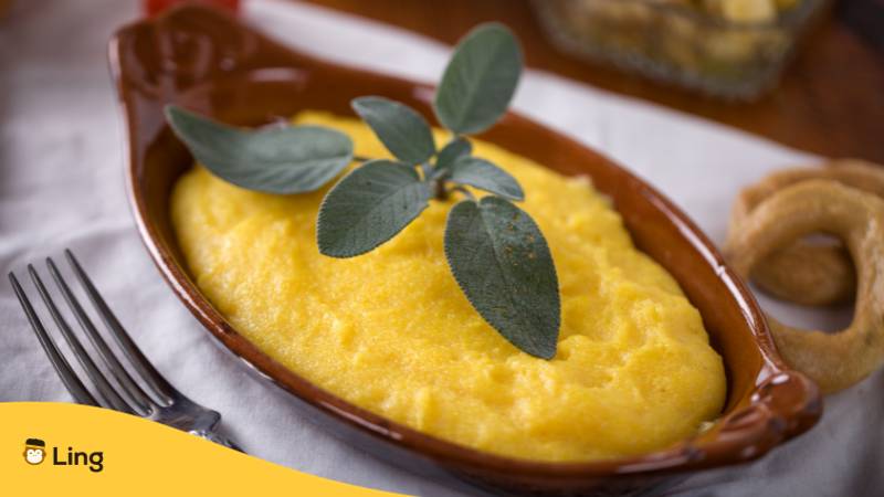 Schale mit Polenta auf welcher ein Salbei Blatt dekoriert ist.