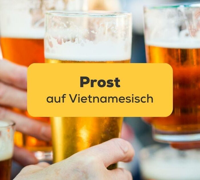 Drei Menschen, die sich gegenseitig mit Biergläsern zuprosten Prost auf Vietnamesisch