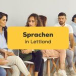 Menschen sitzen auf Stühlen an der Wand und unterhalten sich über die Sprachen in Lettland