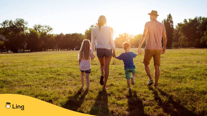 Eltern gehen mit ihren zwei Kindern im Sonnenuntergang spazieren und überlegen sich weitere ukrainische Namen für ihren Nachwuchs